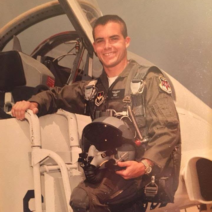 Christopher E. Franklin in his flight suit beside a jet trainer
